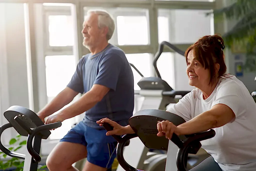 Elderly woman working out in modern gym